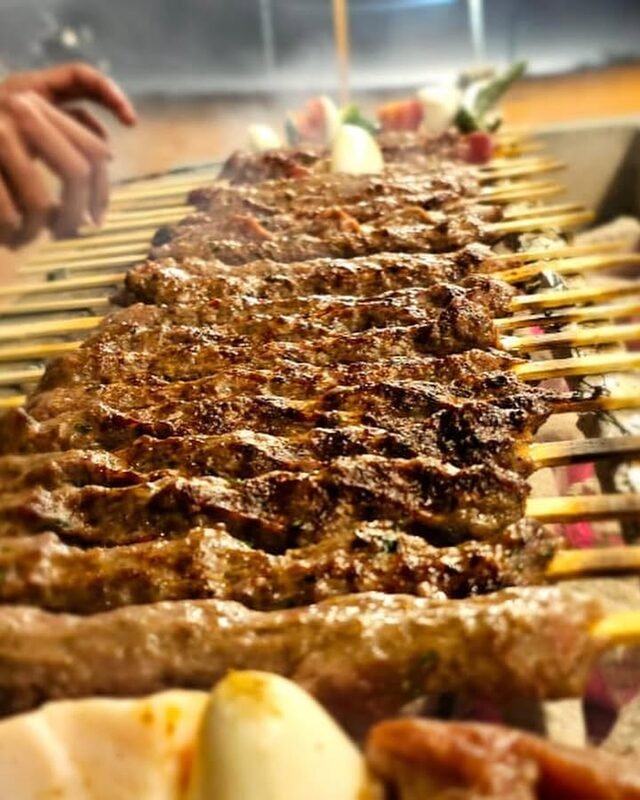 Skewered kebabs grilling over the campfire
