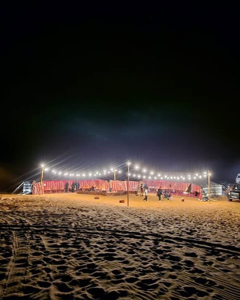 Red striped Bedouin tents lit up at night